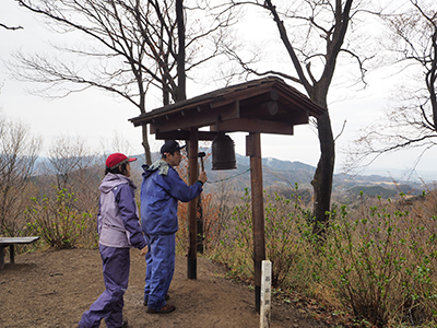 Iさんが撮影した山頂の鐘を突くＫさんと見守るＮさんの写真