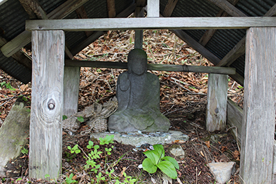 地蔵峠の地蔵とその前に咲くツバメオモトの写真