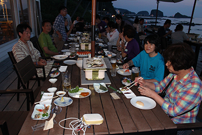 登山後、国民宿舎で夜の海を見ながら夕食中の写真