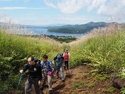 山頂に向けて、溝になった歩きにくい登山道を登っている写真