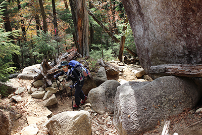 岩の多い登山道を登ってくるＧさんの写真