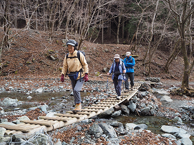 小草平の沢にかかる橋を渡っている写真