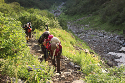 朝日が当たっている登山道を登っている写真