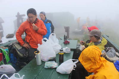 肩の小屋の前で昼食中の写真