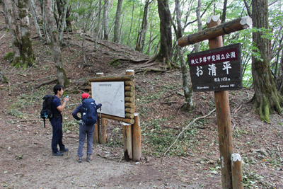 お清平の標識前で地図を見るメンバーの写真