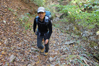 緩やかな登山道を登るMさんの写真