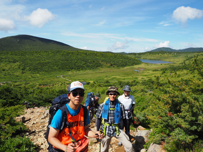 Iさんが撮影した酸ヶ平の湿原を後に見て、登山道を登っているFさんと若い二人の写真