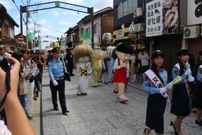 交通安全キャンペーンで、水木ロードを行進する妖怪たちとおまわりさんの写真