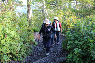 木の葉が色づき始めた登山道を登っているKさんとSさんの写真