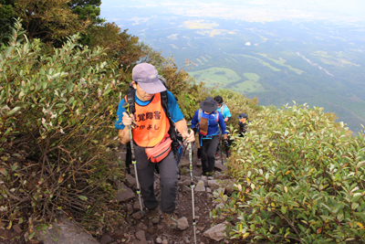 展望のよい登山道を登っているFさんの写真