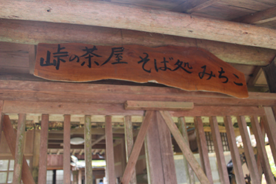 「峠の茶屋 そば処 みちこ」と書かれた気の看板の写真