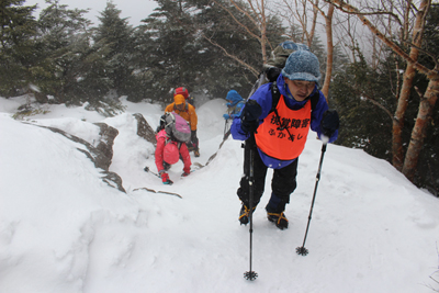 積雪の増えた急斜面を登っている写真