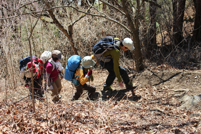 岩の出てきた登山道をＡさんをサポートして登るＫさんの写真