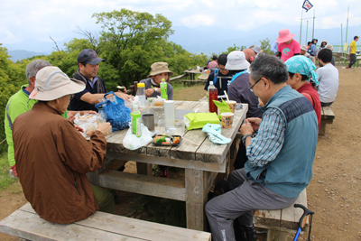 山頂のテーブルで昼食中の写真
