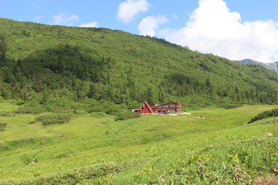 山を背にして佇む黒部五郎小屋の写真