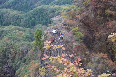 若い男女がすっぱり切れ落ちた岩場の近くにいる写真