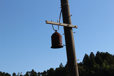 電柱にぶら下げられていたさび付いた鐘の写真