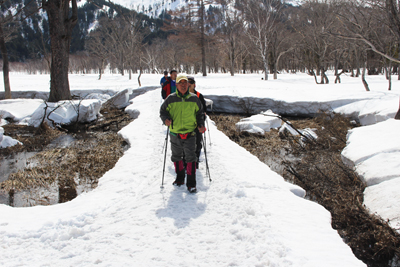 木道の上に2mほど積もった雪の上を歩いている写真