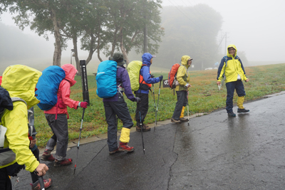 雨の中、舗装道路を歩いている写真