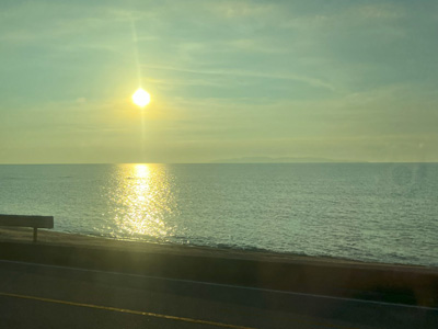 帰路の電車から見た夕日と日本海の写真