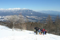 八ヶ岳を背に冬の入笠山に登っている写真へリンク